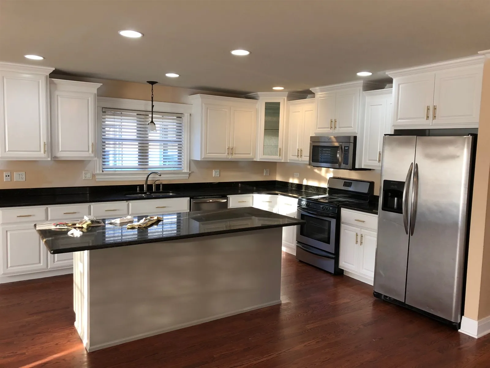 White kitchen with a dark island and stainless appliances